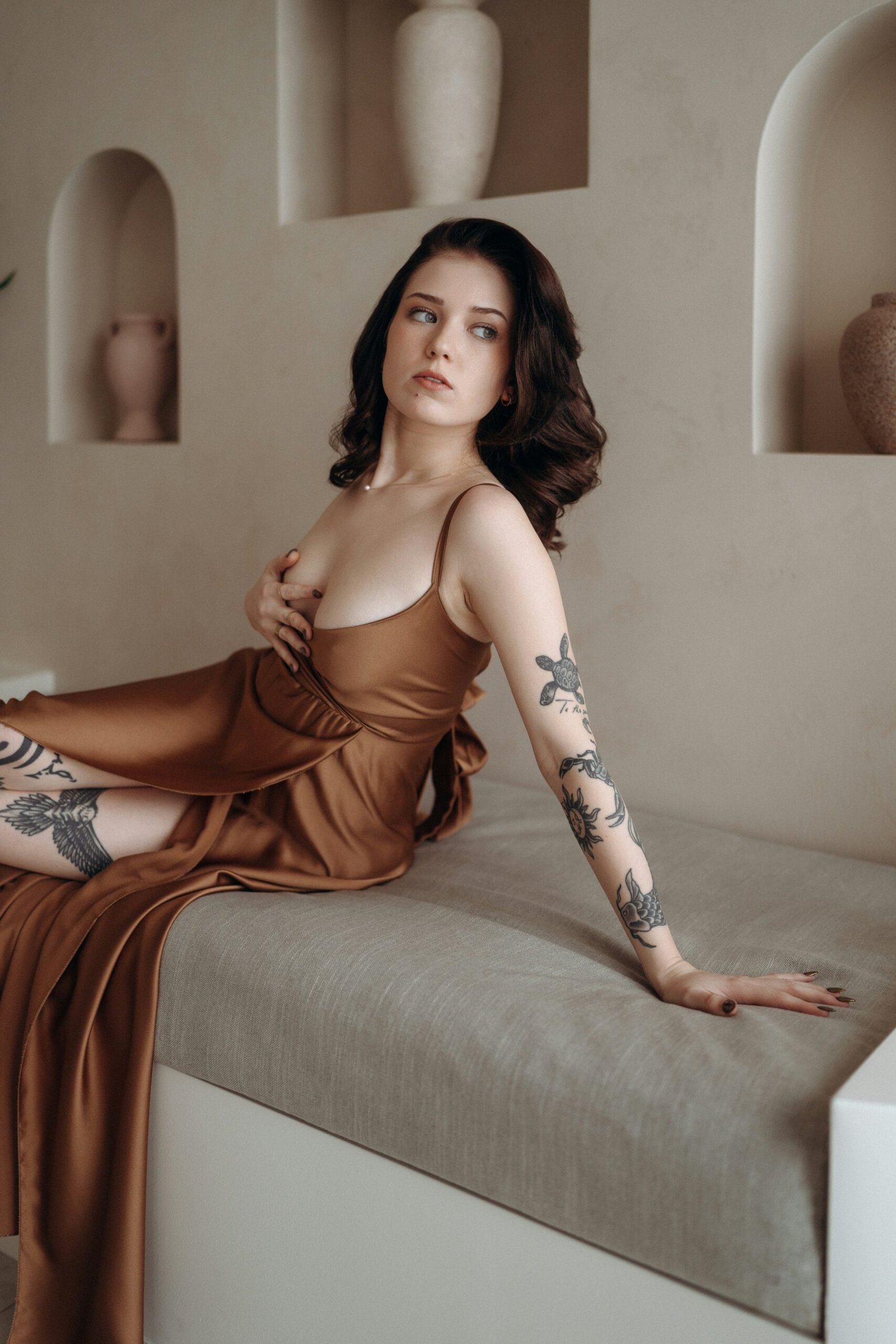 a woman with tattoos sitting on a couch